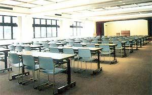 講演会などが行われるようたくさんの長机に椅子が3脚ずつ並べられているふれあいホールの写真
